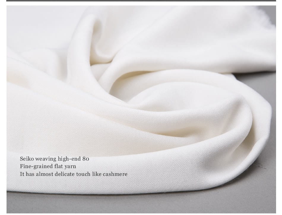 Una bufanda de lana blanca de lujo suave para mujer, con tejido plano de grano fino y una textura delicada reminiscentes del cachemira.