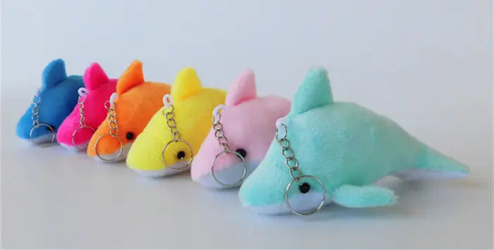 a row of colorful plush dolphin keychains with soft fabric bodies and metallic ring attachments suitable as cute gray kitten bag charm toys