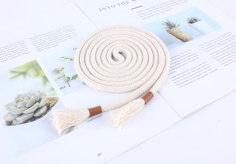 Beige braided rope belt with frayed tassels and brown leather accents designed as a women tassel waistband dress accessory.