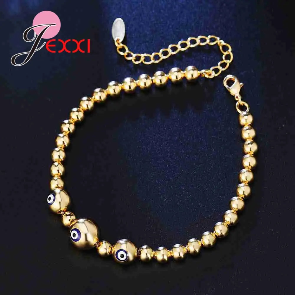 Sterling silver gold-colored beaded bracelet for women featuring three prominent evil eye charms with blue and black detailing.
