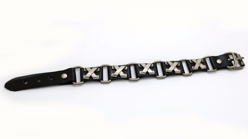 シルバートーンのX字型メタルスタッズと、それに合わせたバックルを備えたブラックレザーパンクブレスレット。