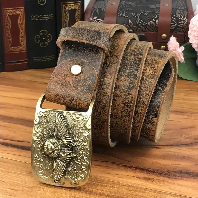 A vintage-style brown genuine leather men jeans belt featuring an ornate brass buckle with a detailed eagle design.
