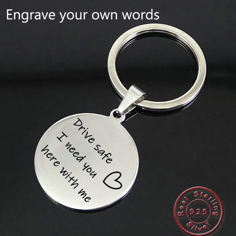 Silver 925 sterling silver keychain with a round disc pendant engraved with drive safe i need you here with me and a heart symbol, custom sterling silver drive safe engraved keychain.