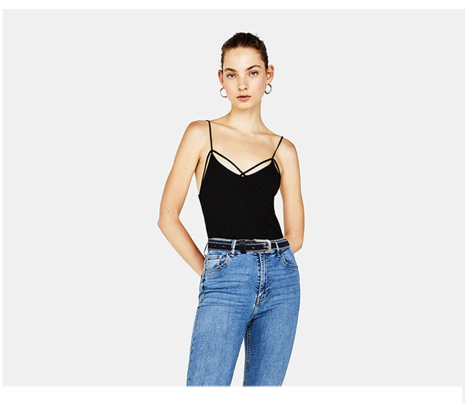 Cinturón de cuero negro para mujer, estilo moda de cinturón de piel de vaca, combinado con una camisol sin tirantes negra tipo spaghetti, con detalle de cuello cruzado.