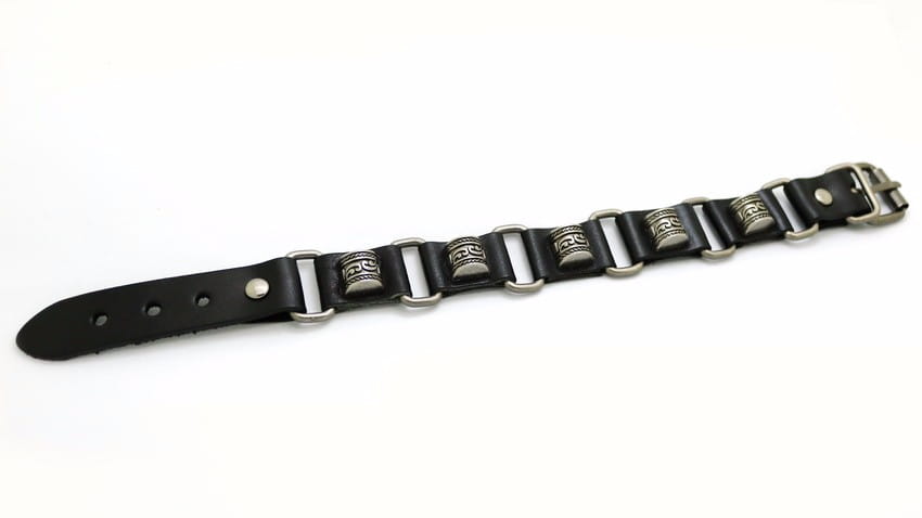 メタルスタッズを備えた、シルバートーンのメタルバックルと装飾的な刻印入り円筒チャームの、ブラックレザーパンクブレスレット