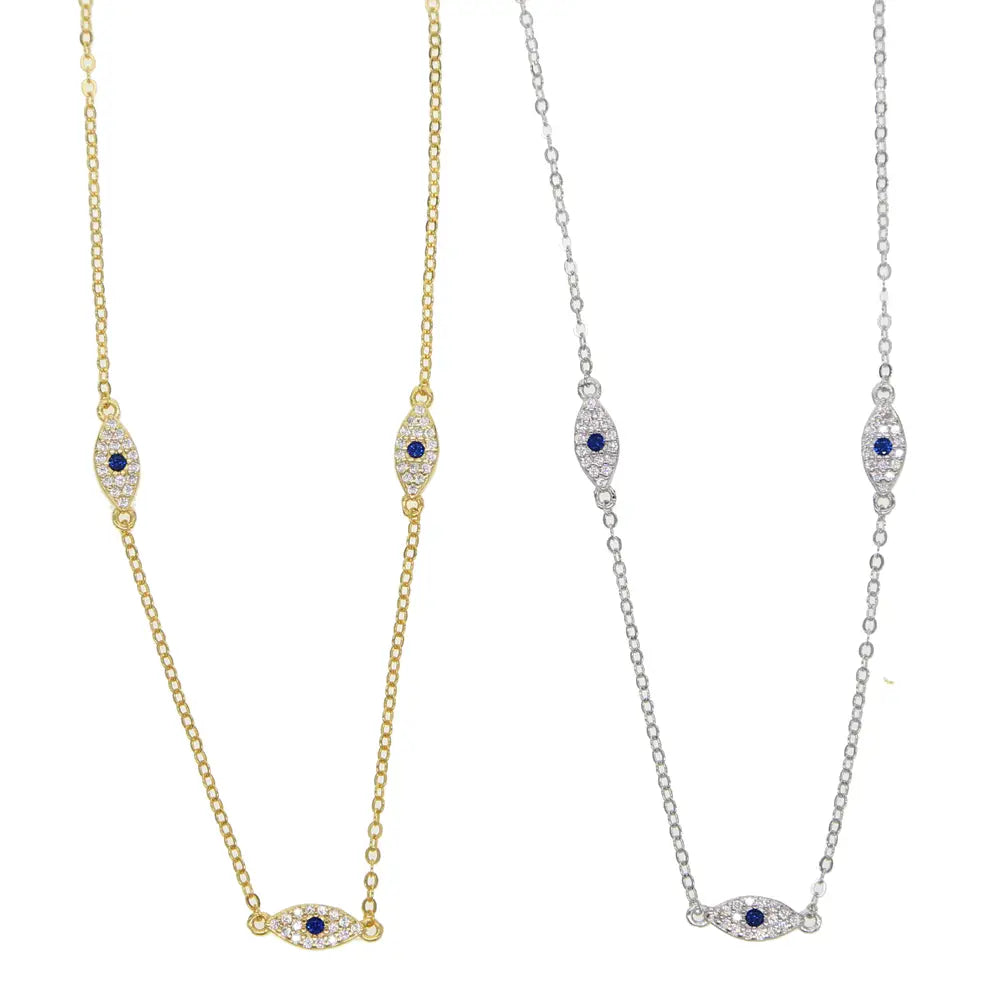 Two delicate eye-shaped charm necklaces in silver-tone and gold-tone featuring pave-set clear cz crystals and a blue gemstone center.
