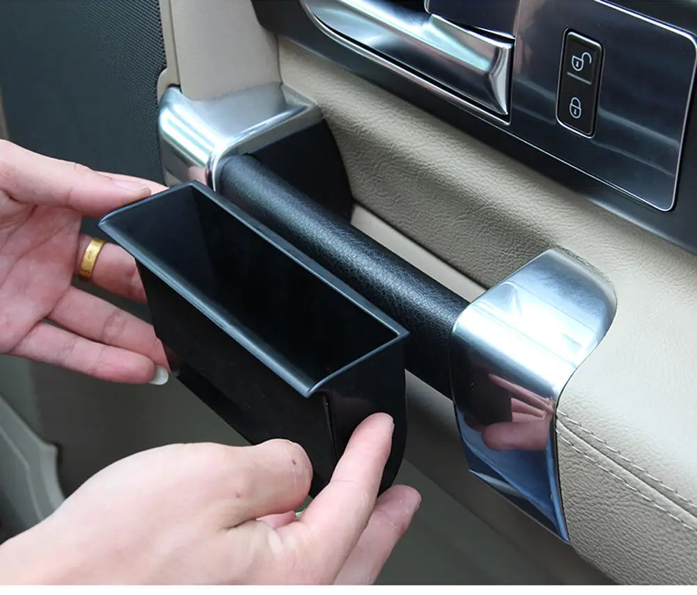 Boîte-plateau de rangement de poignée de porte Land Rover Discovery 4 en plastique noir pour compartiment de porte de véhicule, au design rectangulaire élégant et aux bords lisses.