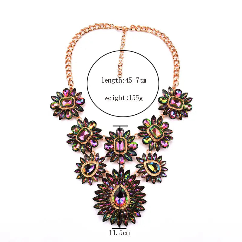 Un collier d’affirmation en cristal, avec une chaîne à tons dorés et une composition élaborée de fleurs en pierres précieuses irisées multicolores, rehaussées de pierres centrales en forme de goutte, dans un style de ras-du-cou bohème.