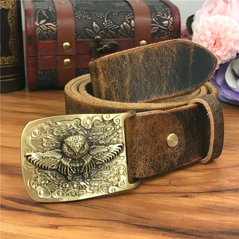 A vintage-style brown leather men jeans belt featuring an ornate brass owl belt buckle.