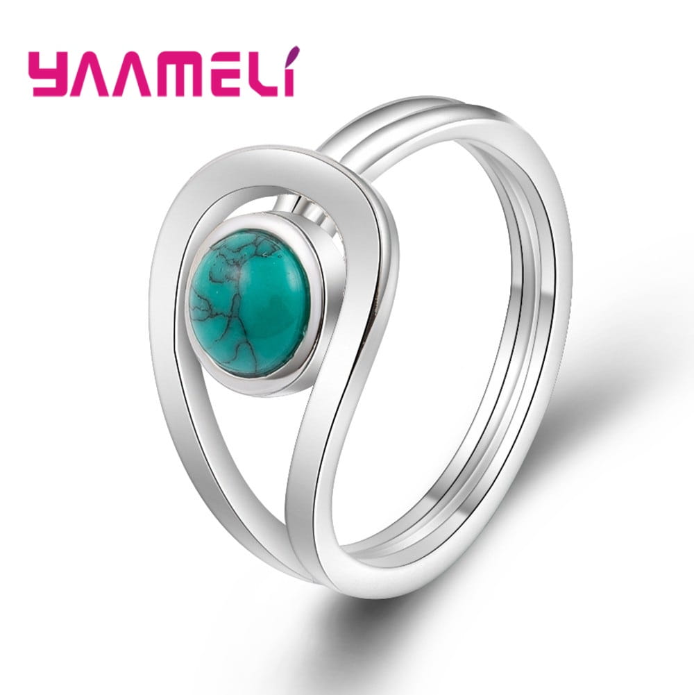 Anillo de plata de ley 925 para mujeres de compromiso de boda, con un diseño yameli de tono plateado y una piedra central de turquesa ovalada con vetas naturales, montada dentro de una estructura de doble banda abierta y fluida.
