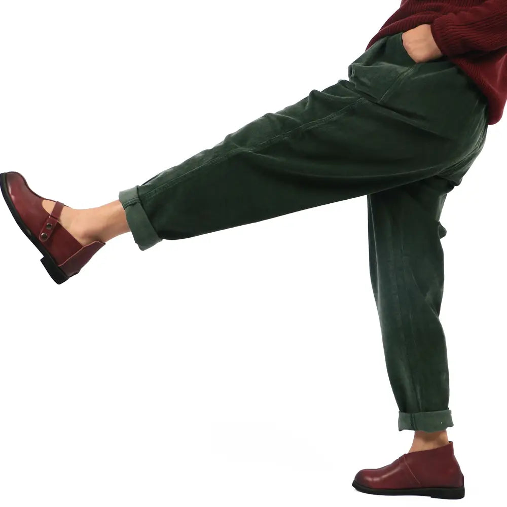 pantalones de pana de pierna ancha verde oscuro con cintura elástica, puños doblados y ajuste holgado, mostrados en imágenes detalladas que resaltan la longitud del pantalón.