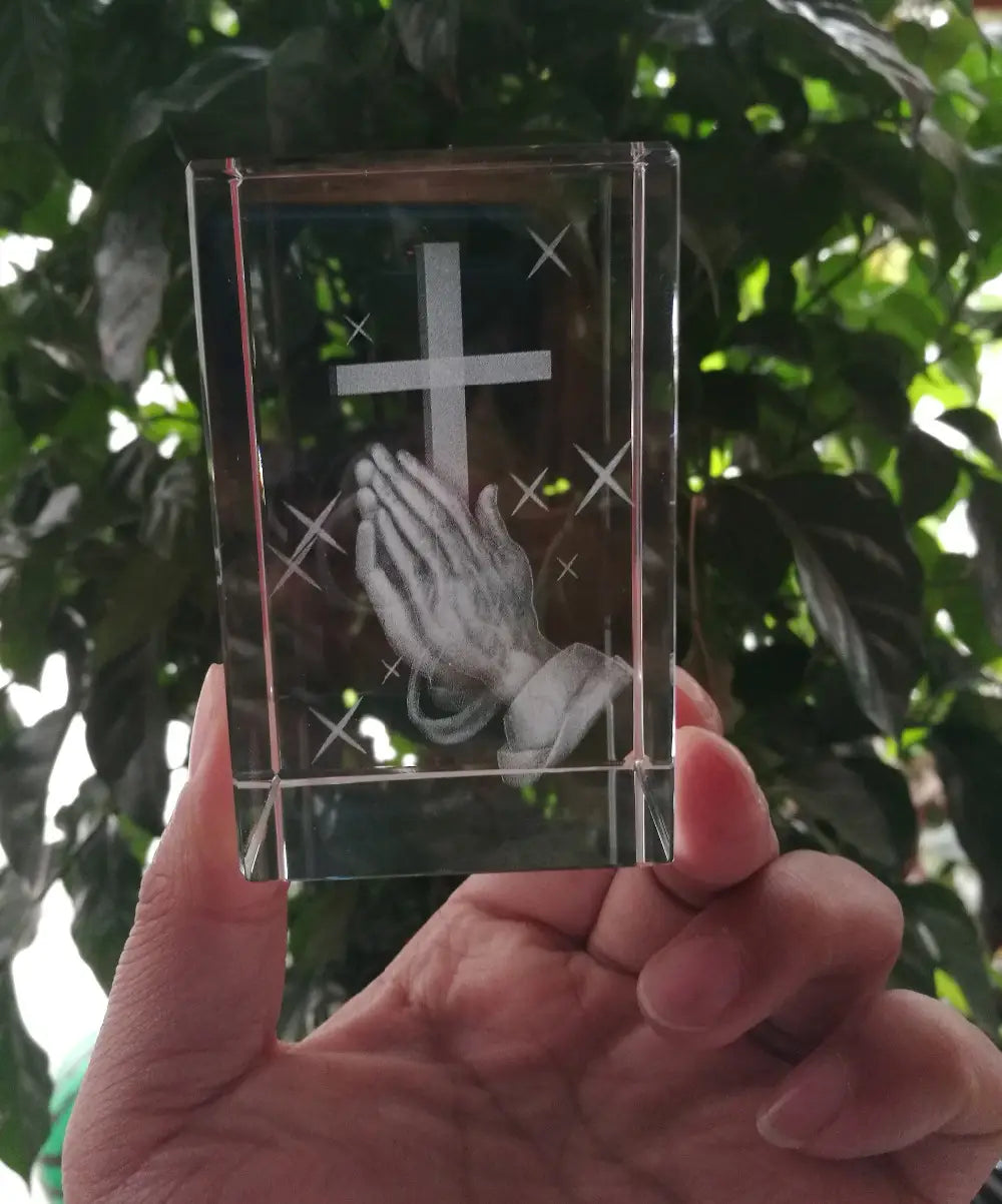 Bloc de cristal transparent 3D en forme de croix, statue de croix en cristal avec mains priantes, présentant une croix gravée et un motif de mains priantes.