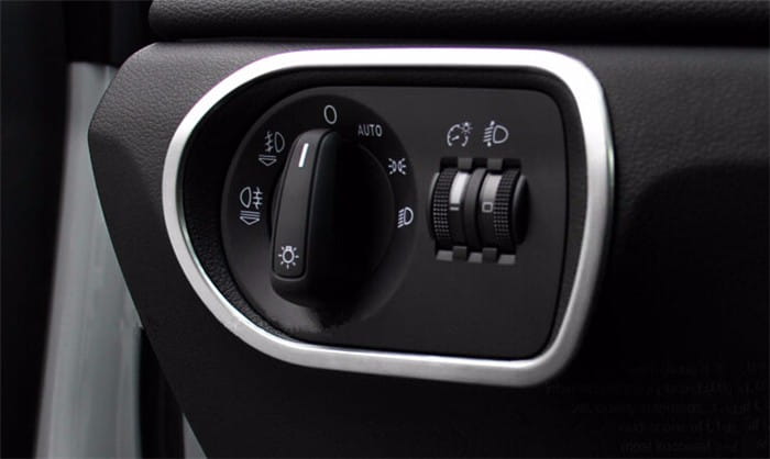 Black plastic headlight control knob with silver trim and illuminated icons for high low beams auto headlights and turn signals in Audi Q3 2012-2016 interior trim decoration set.