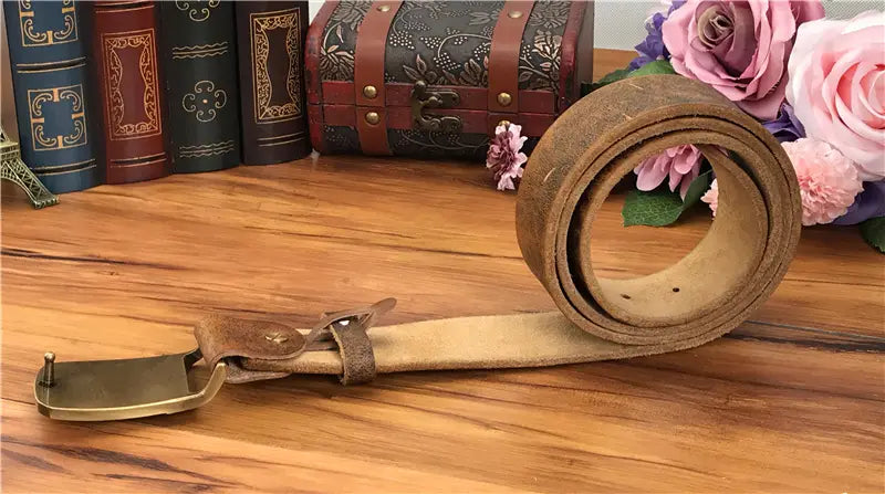 A vintage-style brown leather men jeans belt with a brass owl belt buckle and embossed detailing.