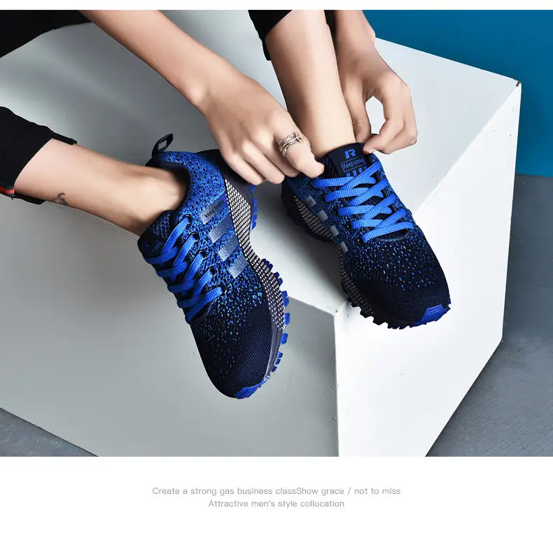 Chaussures de running pour hommes Covadis en maille respirante en tricot bleu et noir, avec des lacets bleu vif conçus pour un usage athlétique.