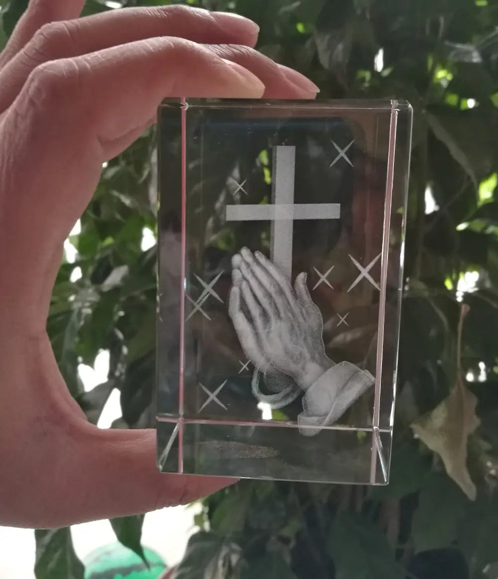 Cube en acrylique transparent 3D en forme de croix en cristal avec mains priantes, présentant une croix gravée et un motif de mains priantes.