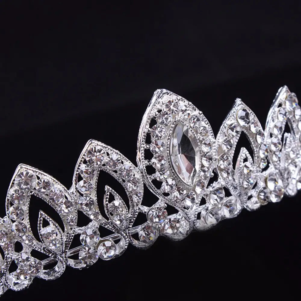 Tiarа de novia de cristal plateado con filigrana intrincada con forma de hojas, cristales transparentes brillantes y una piedra central en talla marquesa para tocado de boda.