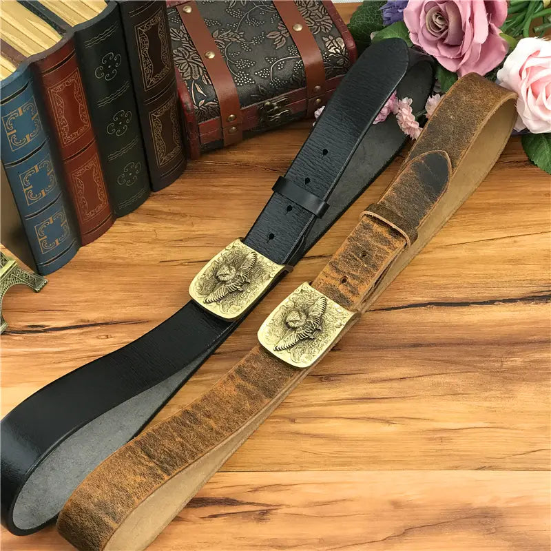 Two genuine leather men’s jeans belts in black and brown with brass owl belt buckles featuring eagle designs.