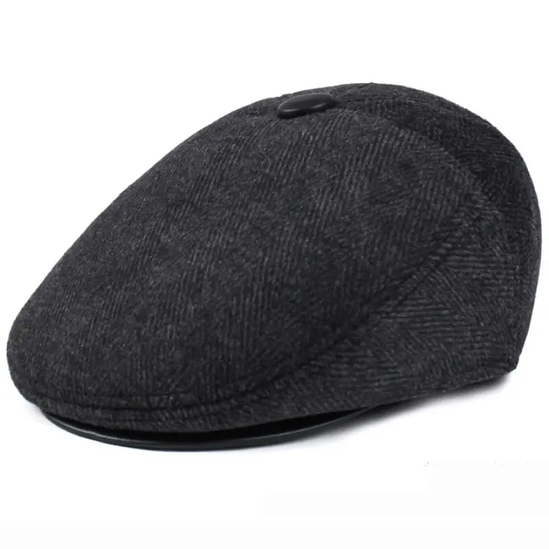 Boina de invierno para hombre en gris oscuro con patrón herringbone, gorra plana con cubreorejas, con botón negro en la parte superior y visera de cuero.