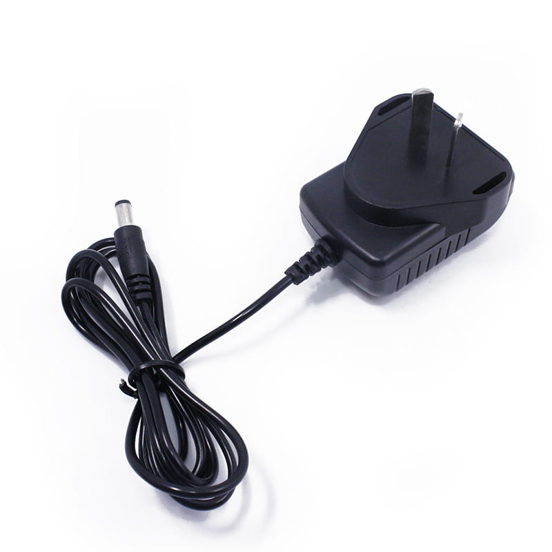 black plastic baofeng uv-5r battery charger with uk-style three-prong plug and coiled cable ending in a cylindrical dc connector for uv5r radios