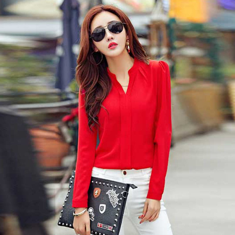 A vibrant red chiffon office blouse with a v-neckline long sleeves and subtle front pleating designed to minimize negative feedback in professional settings.