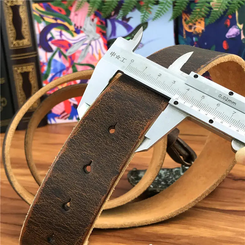 Brown leather genuine leather men jeans belt with brass owl belt buckle features visible stitching and adjustable holes being measured by a metal caliper.