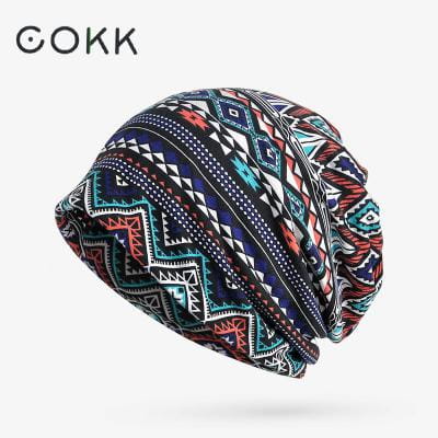Cokk brand floral knit beanie hat unisex casual autumn headwear with a vibrant geometric pattern in navy teal red and black on stretchy fabric.