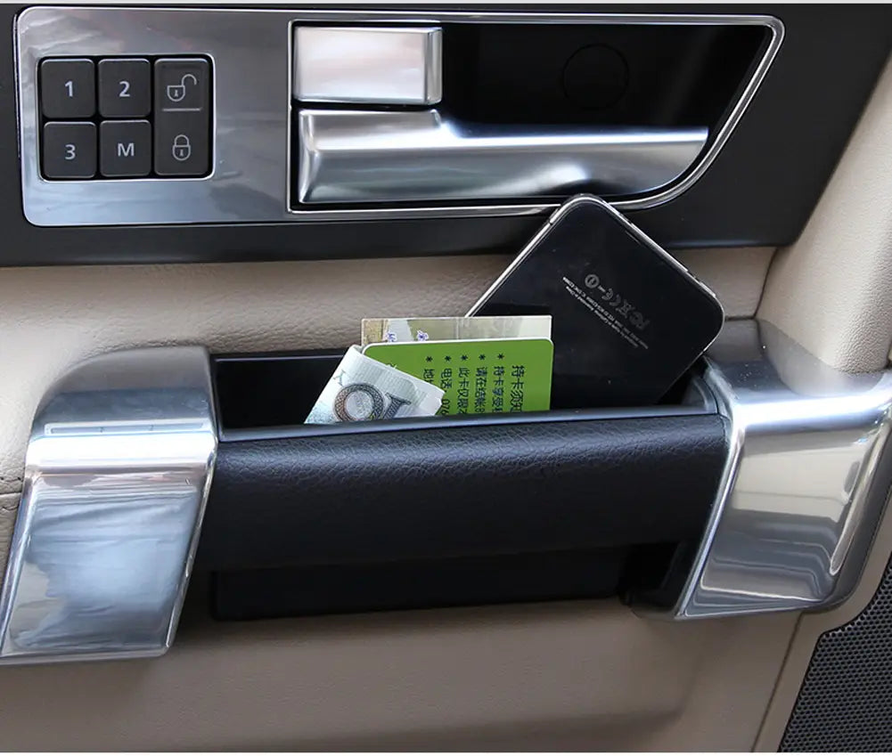 Boîte-plateau de rangement de poignée de porte Land Rover Discovery 4, présentant un compartiment de rangement de porte de véhicule bordé de cuir noir avec des accents chromés.