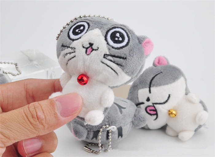 Plush cat keychain cute gray kitten bag charm toy featuring a gray and white plush body with pink inner ears, black embroidered eyes, a red bell around its neck, and a silver chain attached.