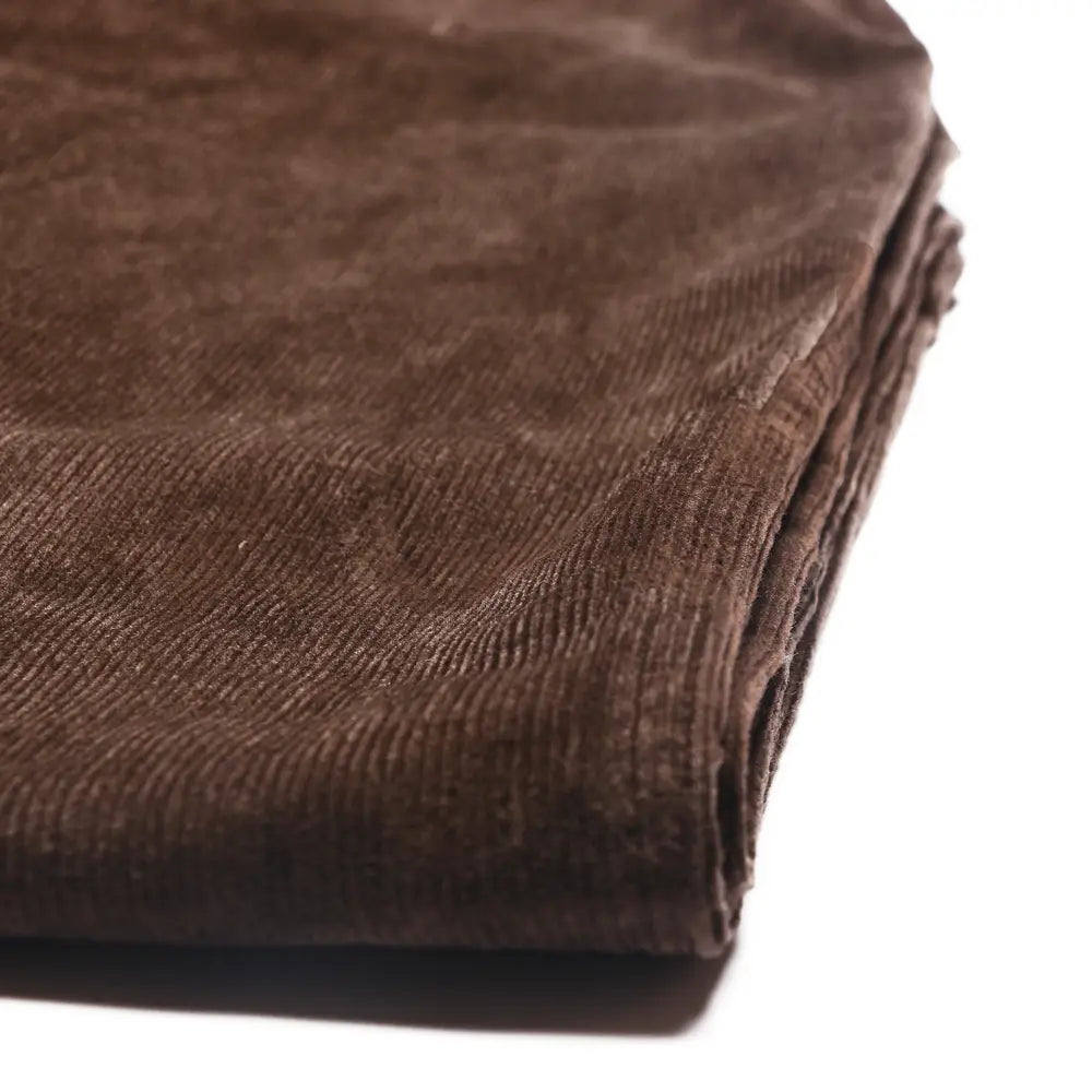 tejido de pana marrón intenso con textura acanalada clásica y superficie acolchada y suave, utilizado para pantalones de pana de pierna ancha con cintura elástica, mostrado en imágenes detalladas que resaltan la calidad de la tela.