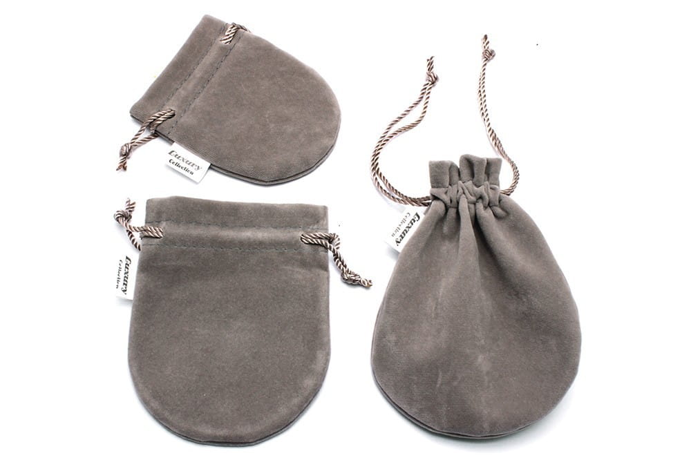 gray suede drawstring pouches with twisted rope ties and small white tags accompanying the black and white crystal statement flower ring