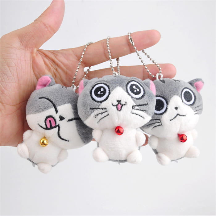 Three gray and white plush cat keychains with pink inner ears black embroidered eyes stitched whiskers and red bells used as cute kitten bag charm toys.
