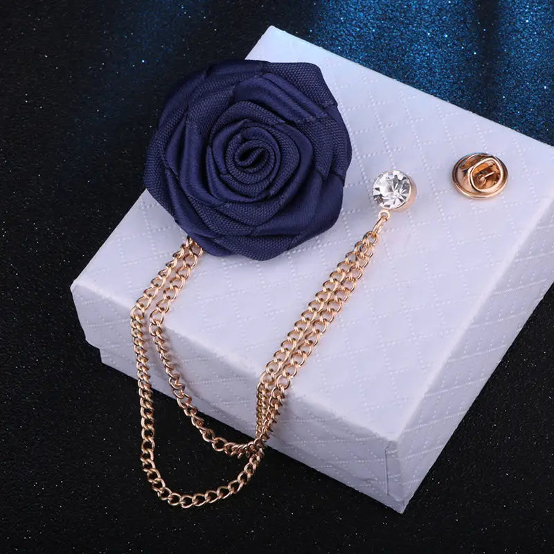 Navy blue fabric rose flower brooch with gold chain and crystal accent designed as a tassel chain men suit pin.