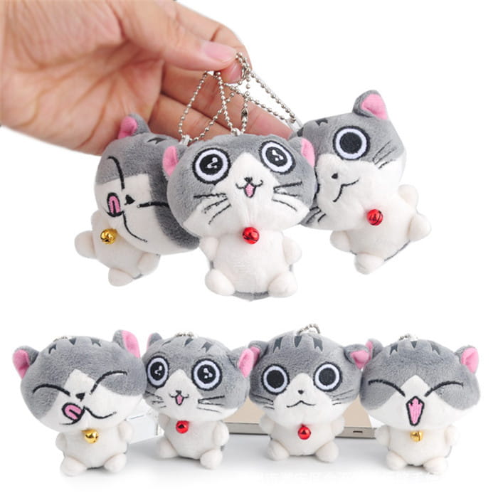 Plush cat keychain featuring cute gray and white plush kittens with pink inner ears, red and gold bells, and stitched facial features designed as a bag charm toy.