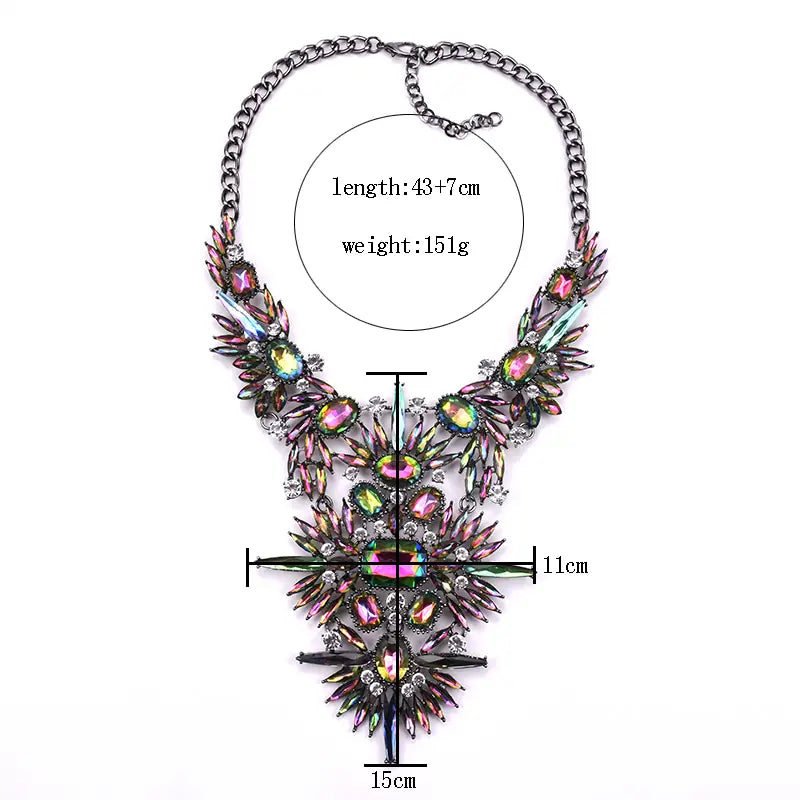 Un collier ras-du-cou bohème multicolore vibrant, présentant un motif floral audacieux, avec des pierres précieuses irisées rose et vert serties dans un cadre métallique complexe.