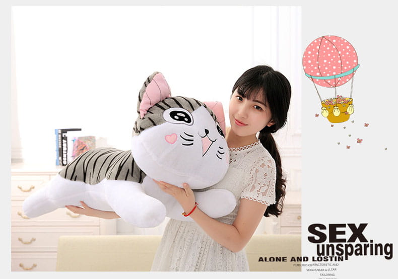 A cheese cat soft animal plush toy featuring a gray and white striped fur pattern, pink inner ears and bow, heart-shaped pupils, smiling face with rosy cheeks, and a soft stuffed body ideal as a soft animal doll.
