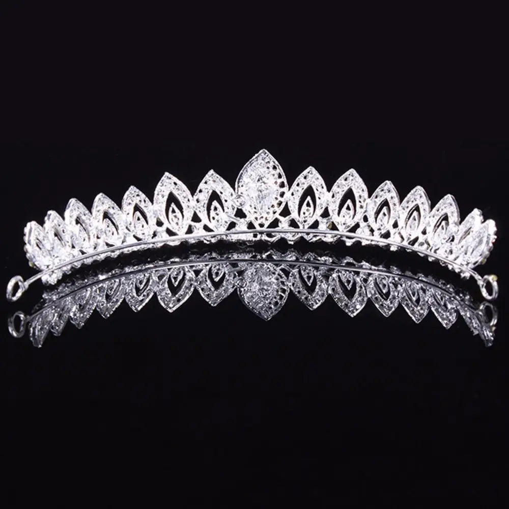 Una tiara de novia de cristal plateado brillante con adornos de cristal con forma de hojas intrincados y un diamante central más grande para su uso como diadema de boda floral.