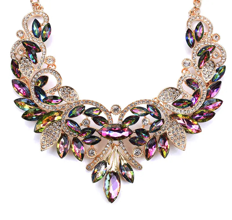 Un collier-sautoir en cristal or rose, orné d’un motif de feuille, avec des cristaux irisés taillés en marquise et de plus petits rhinestones transparents, dans un design bohème multicolore de ras-du-cou.