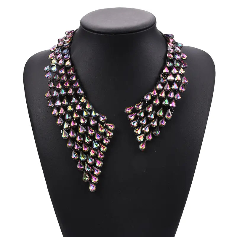 Un collier ras-du-cou bohème multicolore étincelant, avec un design à plusieurs niveaux et des cristaux irisés en forme de gouttes superposées, dans des tons rose et violet.