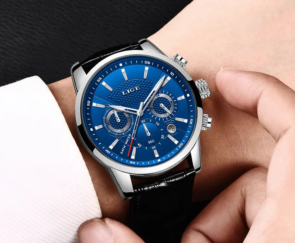 A sleek silver lige men’s leather chronograph quartz watch with a vibrant blue dial three subdials and a black leather strap.