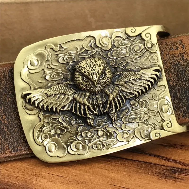 Antique brass owl belt buckle with detailed winged owl and swirling cloud patterns on a genuine leather men’s jeans belt.