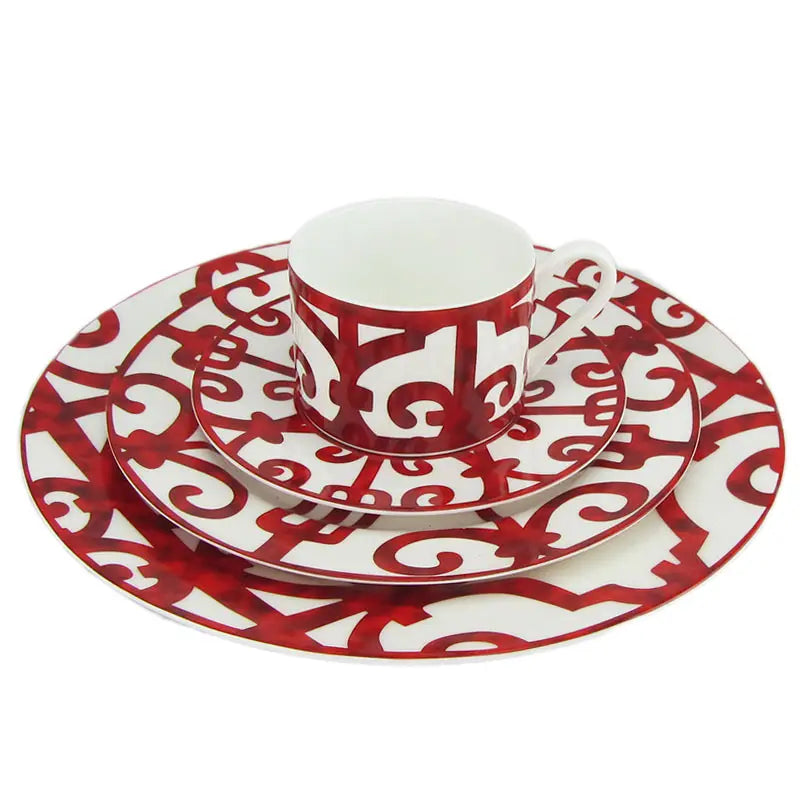 Red and white porcelain coffee cup with intricate swirling pattern from the bone china red scroll dinnerware set.