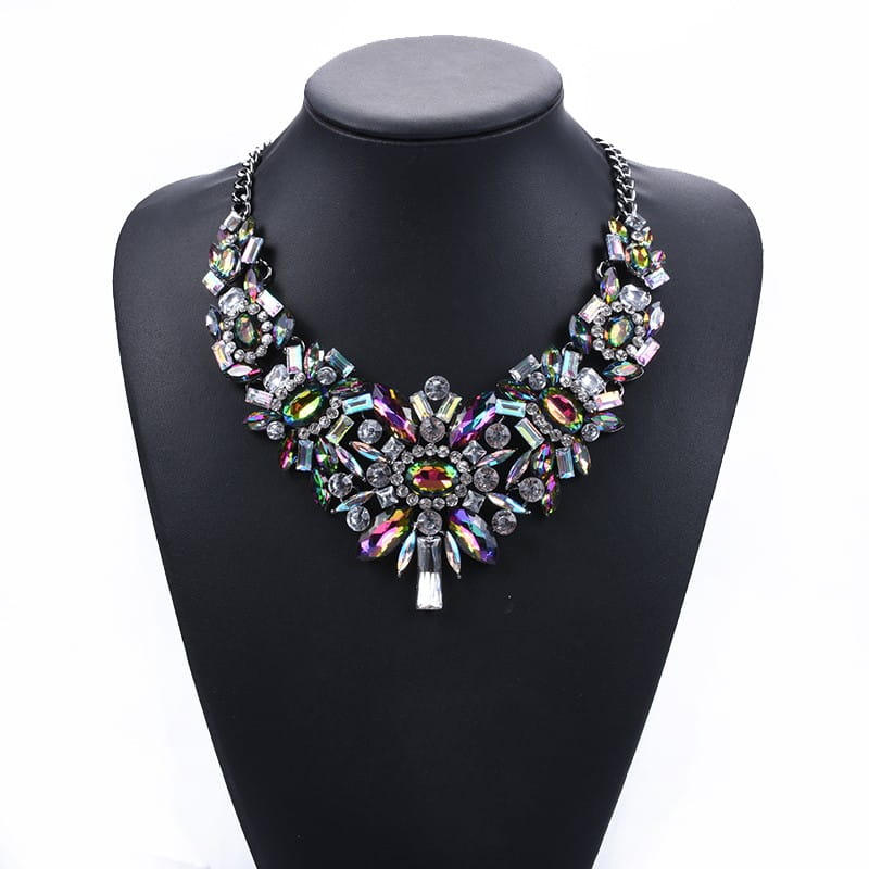Un collier d’affirmation en cristal multicolore éblouissant, avec des cristaux irisés et transparents dans un design audacieux et ornementé, avec un pendentif central.
