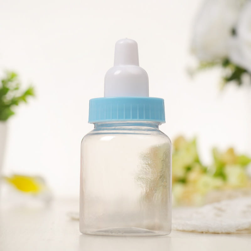 ライトブルーのねじ込み式キャップと白い乳首を備えた透明なプラスチック製のベビーシャワー引き菓子用ミニミルクボトル。