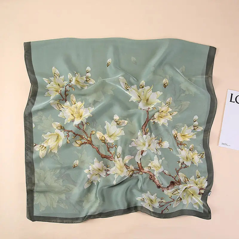 Un foulard en soie menthe délicat arborant un élégant motif floral de fleur blanche, avec des branches brunes et une bordure gris foncé, issu de la collection des amandiers en fleurs de Van Gogh