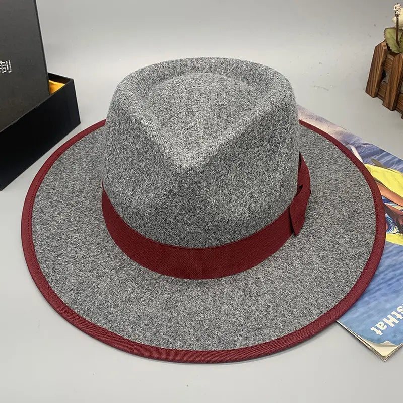 Gray woolen felt fedora hat with a contrasting red ribbon band and feather accent designed for unisex wear.