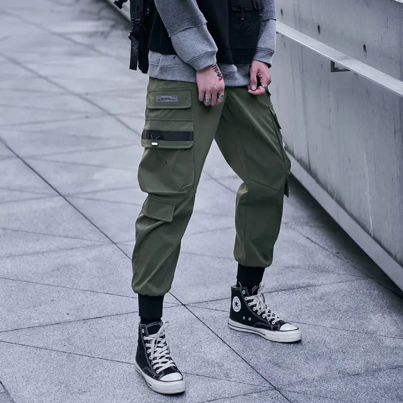 Herren schwarze taktische Cargo-Jogginghosen in Olivgrün mit mehreren Taschen und schwarzen Zierkanten für den Streetwear-Einsatz.