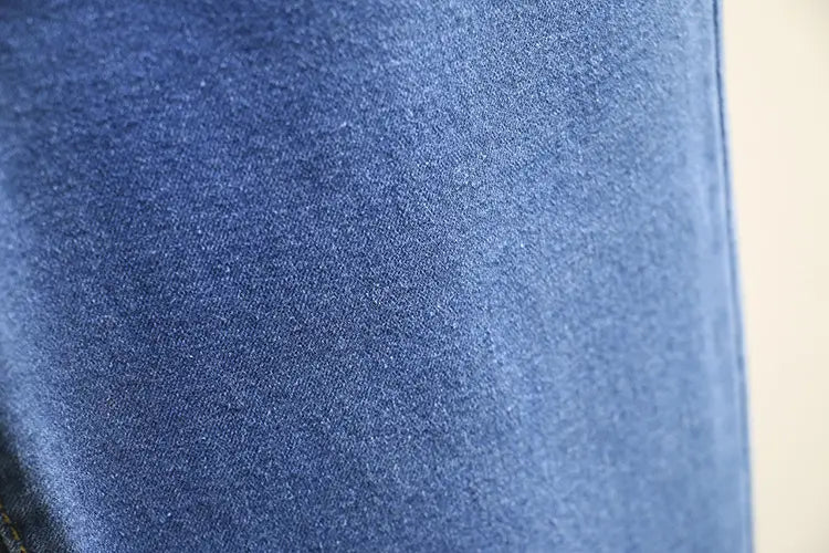 Tissu de jeans en denim bleu clair extensible taille haute, présentant un motif tissé texturé dans la matière en denim bleu.