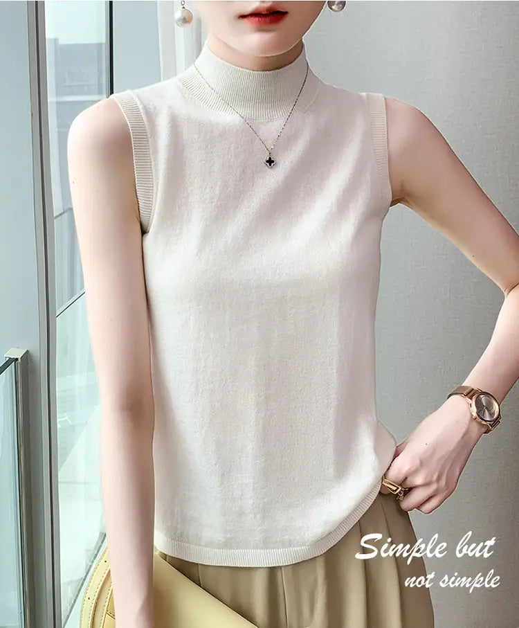 A soft off-white wool turtleneck sleeveless sweater vest with a high neckline and ribbed trim.