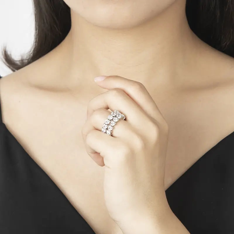 Une bague d’éternité cœur en argent sterling, dotée d’une bande argentée étincelante ornée de plusieurs diamants ronds taillés, disposés dans une rangée continue et élégante.